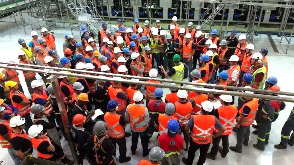 Engenheiros analisando planta da obra industrial